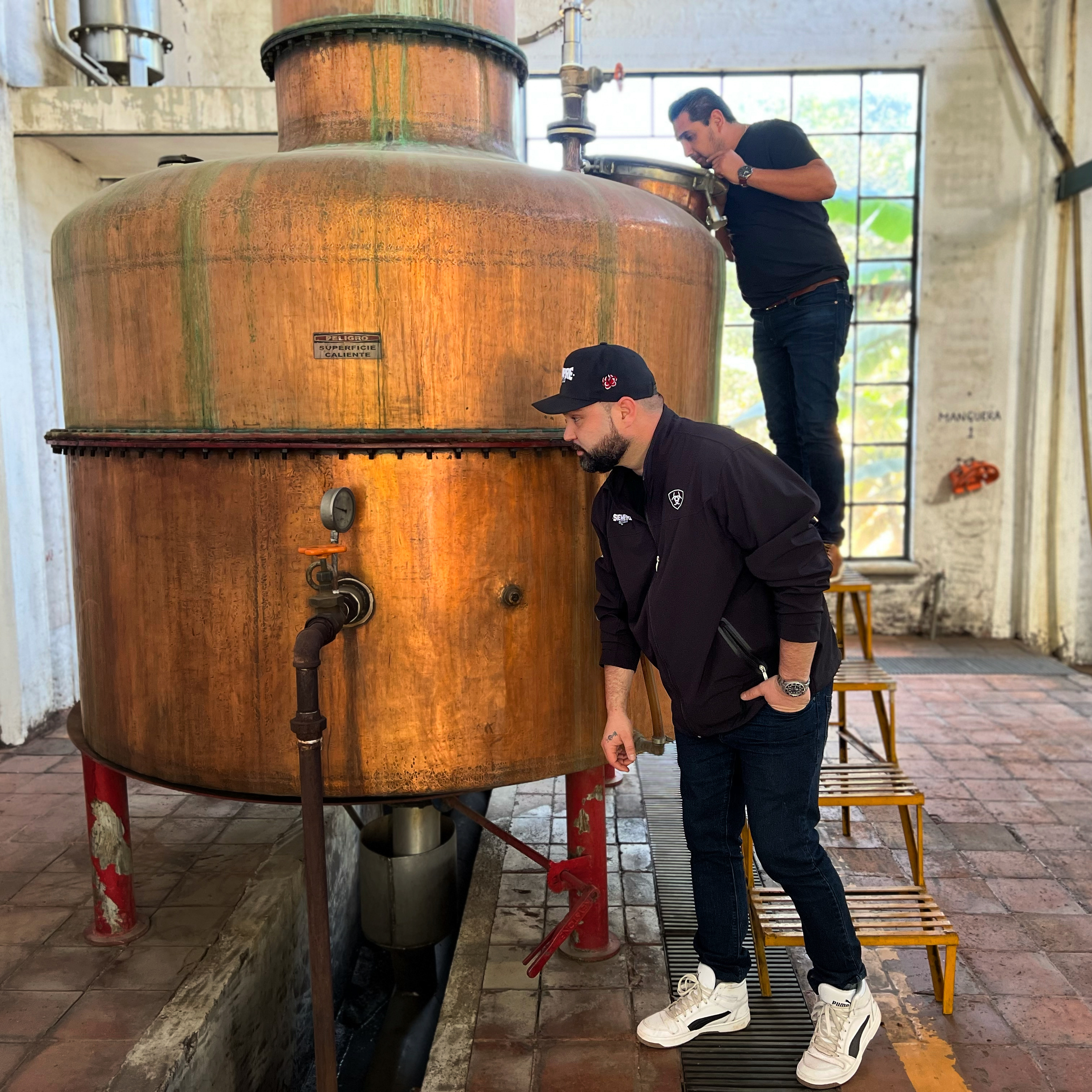 Inspecting a copper pot still at the distillery