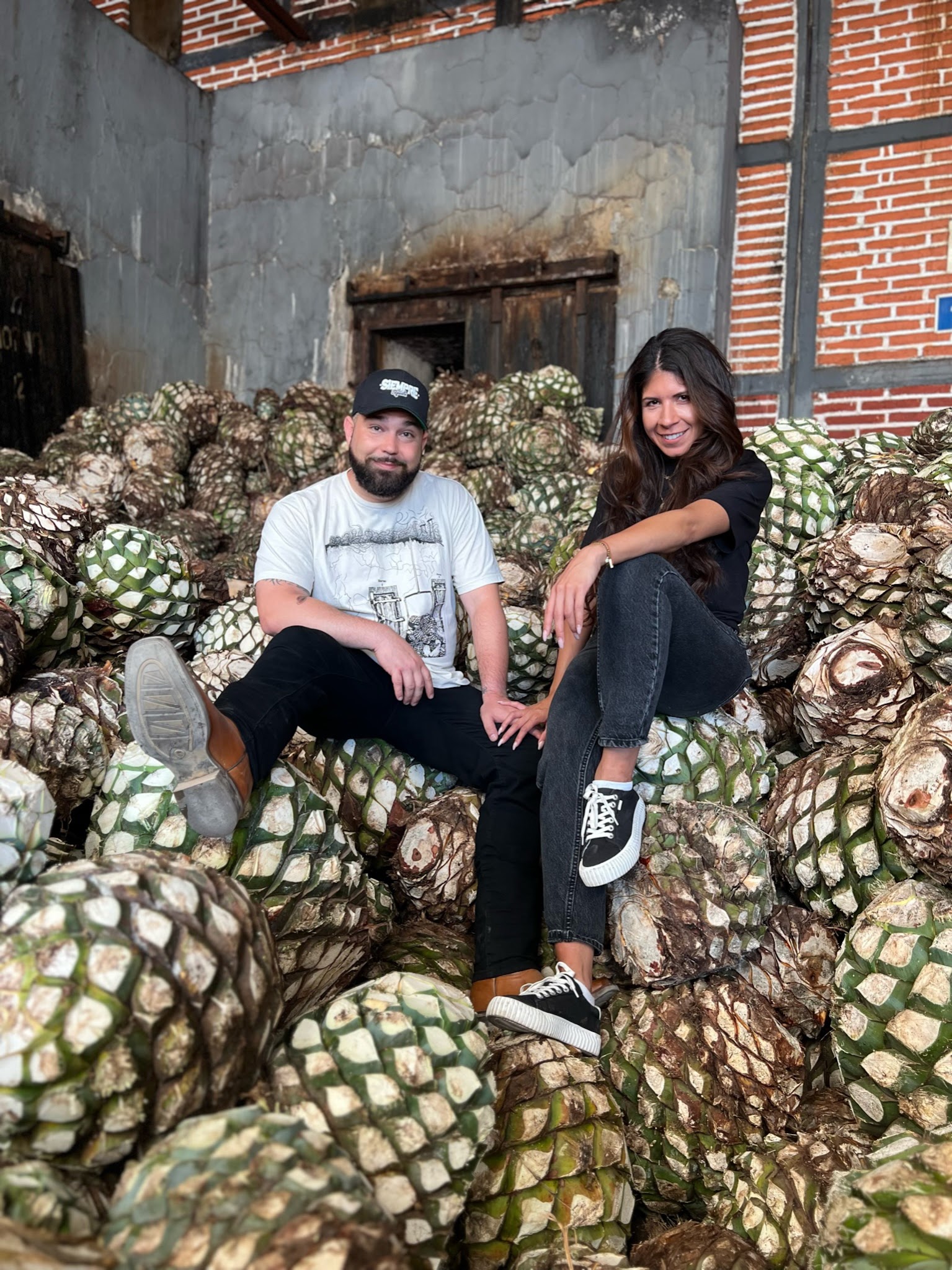 The Siempre founders among harvested agave at the distillery